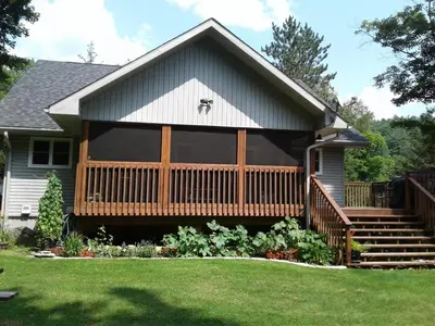 a house with a large porch with a deck at Stone Ridge Chalet Bed n Breakfast in Dorset