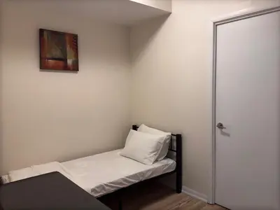 a small room with a bed with a picture on the wall at A lovely one bed room with Sunset Views in Toronto