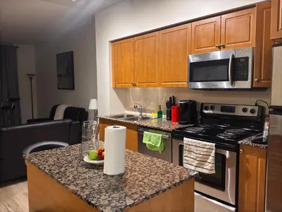 a kitchen with wooden cabinets and a counter top at A lovely one bed room with Sunset Views in Toronto