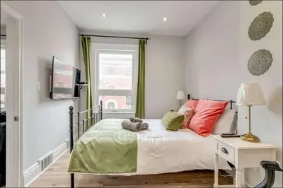 a bedroom with a bed with red and green pillows at Casa Queen - Unique 2BR Suite in Leslieville in Toronto