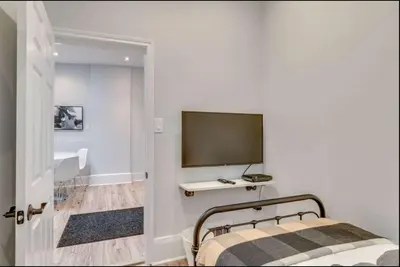 a bedroom with a bed and a flat screen tv at Casa Queen - Unique 2BR Suite in Leslieville in Toronto