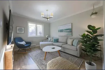 a living room with a couch and a table at Casa Queen East - Modern 2BR Suite in Leslieville in Toronto