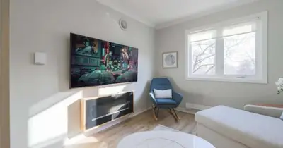 a living room with a couch and a tv at Casa Queen East - Modern 2BR Suite in Leslieville in Toronto