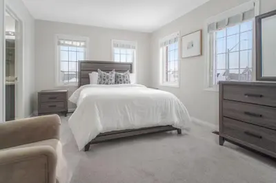 a white bedroom with a bed and a couch at The Bliss in Bowmanville
