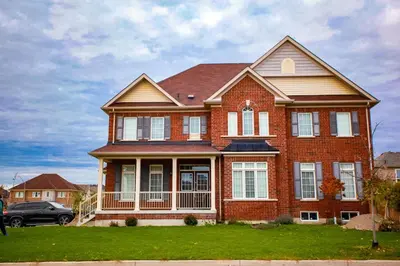 a brick house with a car parked in front of it at The Bliss in Bowmanville