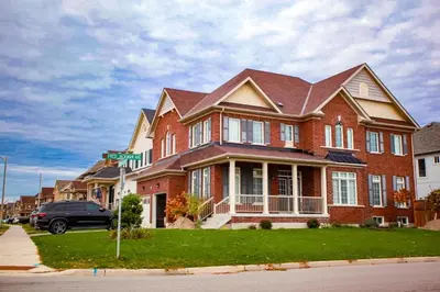 a large brick house on the corner of a street at The Bliss in Bowmanville
