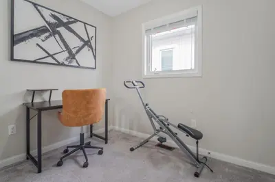 a chair and a desk in a room with a window at The Bliss in Bowmanville