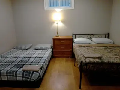 a bedroom with two beds and a lamp on a dresser at Cheap Rooms in Kitchener Best For Students ,Long Term Guests in Kitchener