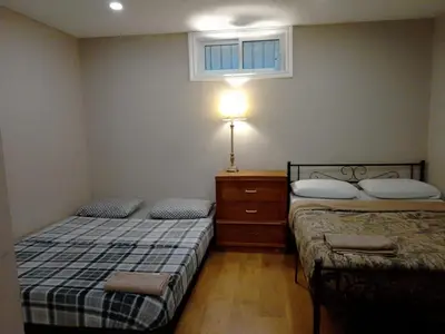 a bedroom with two beds and a lamp and a window at Cheap Rooms in Kitchener Best For Students ,Long Term Guests in Kitchener