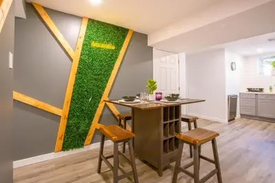 a dining room with a green wall with a table and chairs at Beautiful Apartment 5 mins from Innisfil Beach in Innisfil