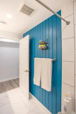 a bathroom with blue walls and white towels at Beautiful Apartment 5 mins from Innisfil Beach in Innisfil