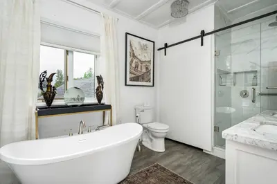 a white bathroom with a tub and a toilet at 3bed 2bath heritage duplex - Prime Location in Collingwood