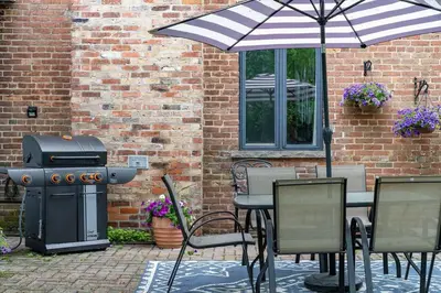 a grill and a table and chairs with an umbrella at 3bed 2bath heritage duplex - Prime Location in Collingwood