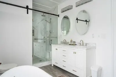 a white bathroom with a shower and a sink at 3bed 2bath heritage duplex - Prime Location in Collingwood