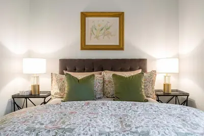a bedroom with a large bed with two lamps at 1 bedroom Garden Suite with parking, Best Location in Collingwood