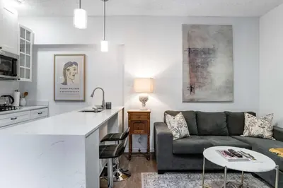 a kitchen and living room with a couch and a table at 1 bedroom Garden Suite with parking, Best Location in Collingwood