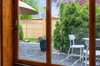 an open door to a patio with a table and chairs at 1 bedroom Garden Suite with parking, Best Location in Collingwood