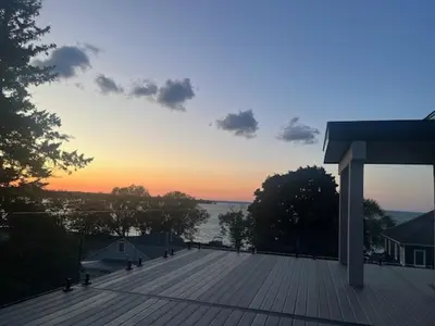 a view of a deck with a sunset in the background at The Lake House in Georgina