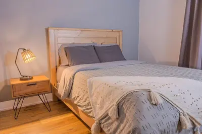 a bedroom with a bed and a lamp on a night stand at 6 Bedroom Modern Escape in Horseshoe, Pool and Hot tub in Coldwater