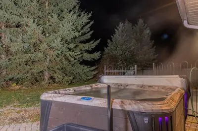 a hot tub in a backyard with trees in the background at 6 Bedroom Modern Escape in Horseshoe, Pool and Hot tub in Coldwater