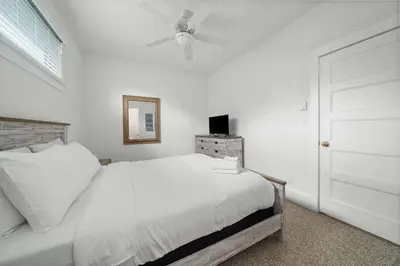 a white bedroom with a bed and a ceiling fan at The Sweetgrass - 57 Butternut in Cherry Valley