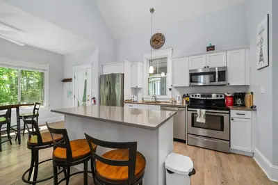 a kitchen with white cabinets and a table and chairs at The Jack Pine - 50 Hollow in Cherry Valley