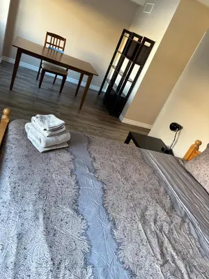 a bedroom with a bed with a table and a chair at 2 beds suit in Kitchener