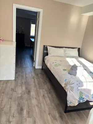a bedroom with a bed with a wooden floor at 2 beds suit in Kitchener