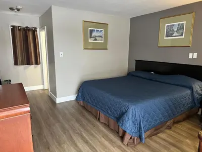 a bedroom with a bed with a blue blanket at Kitchener Motel in Kitchener
