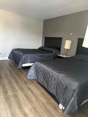 two beds in a hotel room with wood floors at Kitchener Motel in Kitchener
