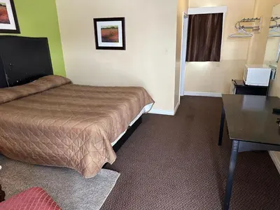 a hotel room with a bed and a desk at Kitchener Motel in Kitchener