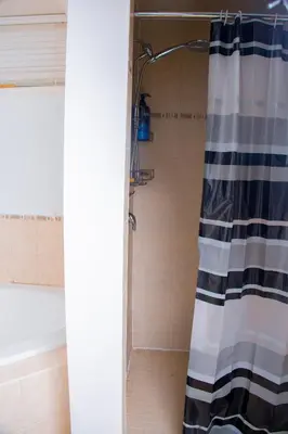 a shower with a black and white shower curtain in a bathroom at Cozy relaxation haven 1 Bedroom basement in London