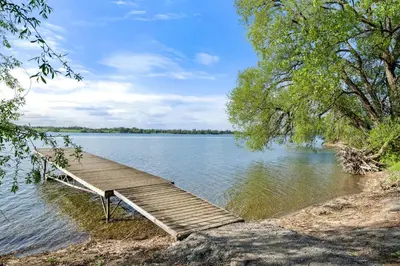 a wooden dock sitting on the side of a lake at The Kiskadee - 49 Butternut in Cherry Valley