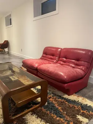 a red leather couch in a living room at McCracken's Mid Century Modern Luxury Cottage in Burleigh Falls