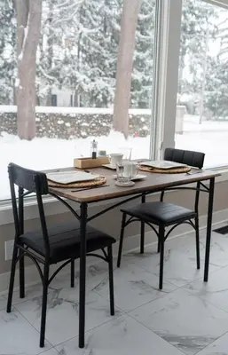a dining room table with two chairs in front of a window at Serenity on the Lake in Niagara on the Lake