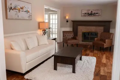 a living room with a white couch and a fireplace at Serenity on the Lake in Niagara on the Lake