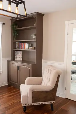 a living room with a chair and a book shelf at Serenity on the Lake in Niagara on the Lake