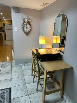 a desk with a mirror and a table with chairs at Entire Basement Apartment in Toronto