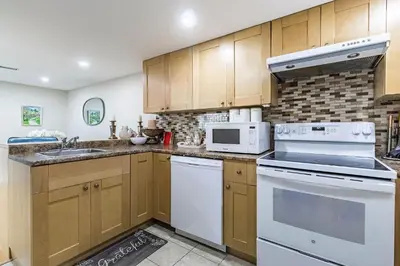 a kitchen with wooden cabinets and white appliances at Entire Basement Apartment in Toronto