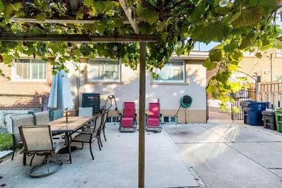 a patio with a table and chairs under an umbrella at Entire Basement Apartment in Toronto