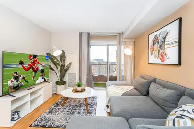 a living room with a couch and a tv at High-End 2BR 2BATH Condo-Steps to Square One Mall in Mississauga