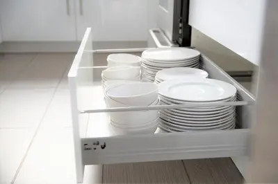 a group of white plates and bowls in a cabinet at Relax at The Mountaintop Chalet in Blue Mountains