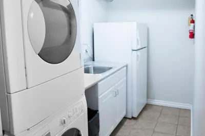 a white kitchen with a sink and a refrigerator at Relax at The Mountaintop Chalet in Blue Mountains