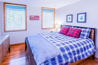 a bedroom with a bed with red and blue pillows at Relax at The Mountaintop Chalet in Blue Mountains