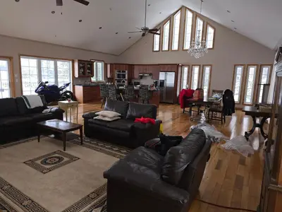 a living room with leather couches and a kitchen at Cottage apartments at Lake Huron in Midland