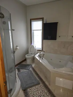 a bathroom with a tub and a toilet and a sink at Cottage apartments at Lake Huron in Midland