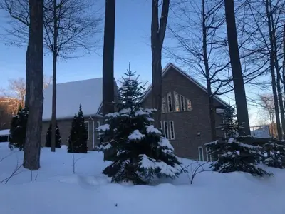 a christmas tree in the snow in front of a house at Cottage apartments at Lake Huron in Midland