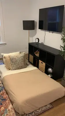 a bedroom with a bed with a television on the wall at 1BR Apartment Near Queen West in Toronto
