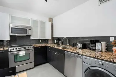 a kitchen with stainless steel appliances and black cabinets at 1BR Apartment Near Queen West in Toronto