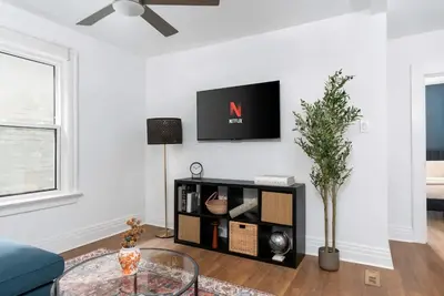a living room with a couch and a tv on a wall at 1BR Apartment Near Queen West in Toronto